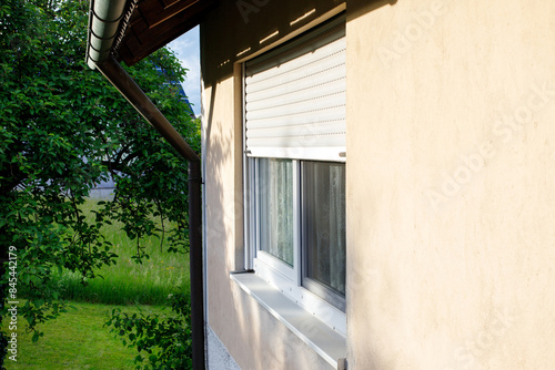exterior view of a window in a house with roller shutters