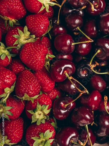 Mix of fresh ripe strawberries and sweet cherry background. Closeup, top view.