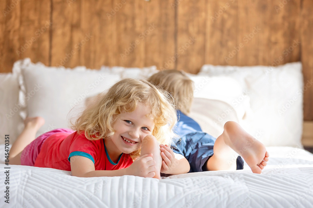 Cute sweet toddler children, tickling feet on the bed, laughing and smiling Cute sweet toddler children, tickling feet on the bed, laughing and smiling