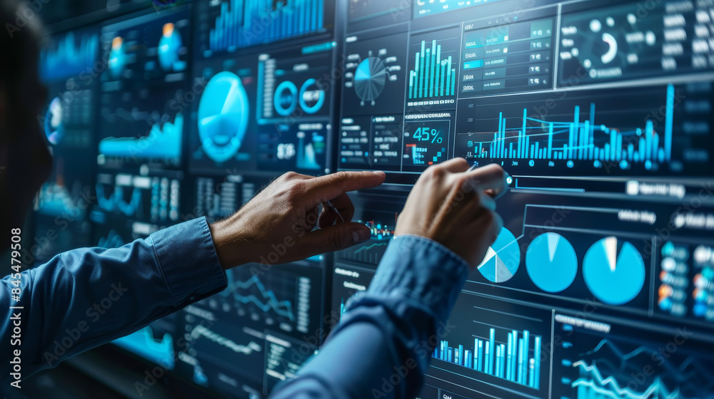 Business professionals analyzing data on large digital screens in a modern office setting
