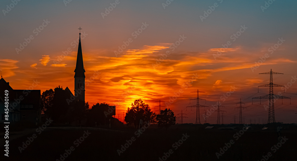 Obraz premium Sunset with a church silhouette near Wallerdorf, Künzing, Deggendorf, Bavaria, Germany