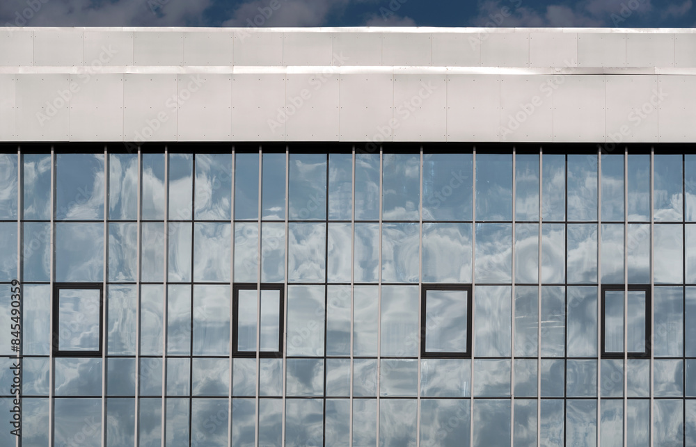 Fototapeta premium empty glass windows of a modern building with a reflection of the sky in the glass