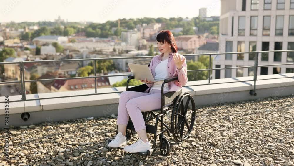 Young beautiful woman in wheelchair has video chat during business conference. Outdoor online remote work and disability concept. Young beautiful woman in wheelchair has video chat during business conference. Outdoor online remote work and disability concept.