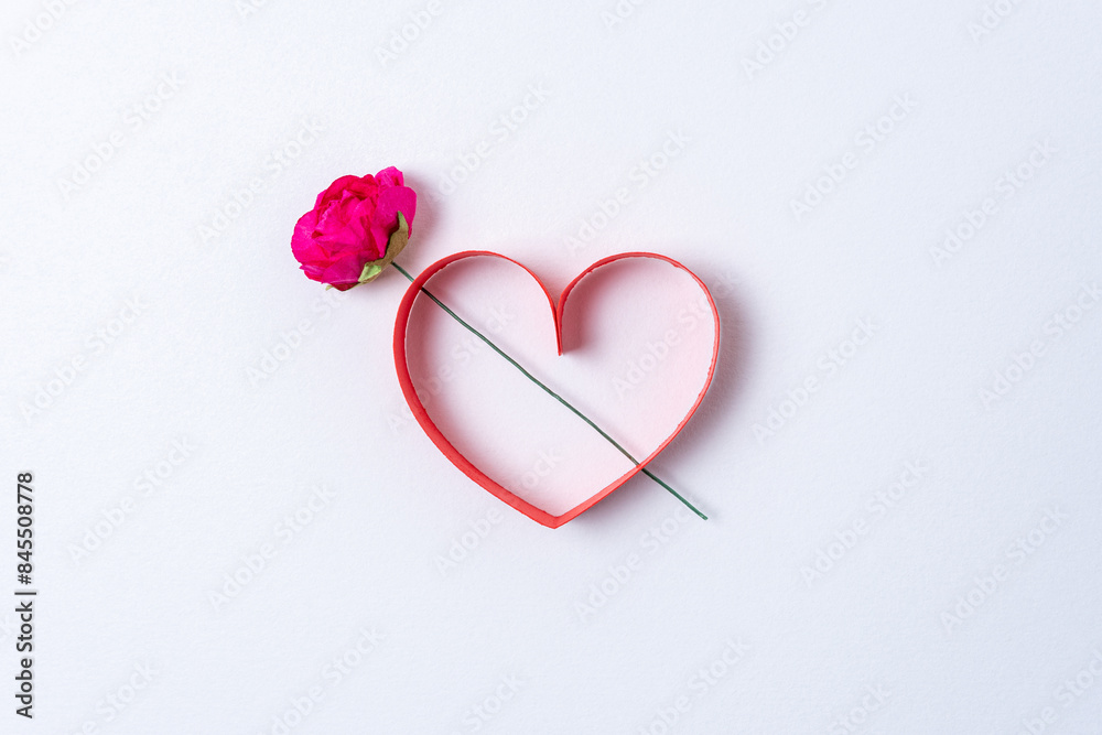 Fototapeta premium Red paper heart shape with flower on white background. Creative minimal love concept. Flat lay.