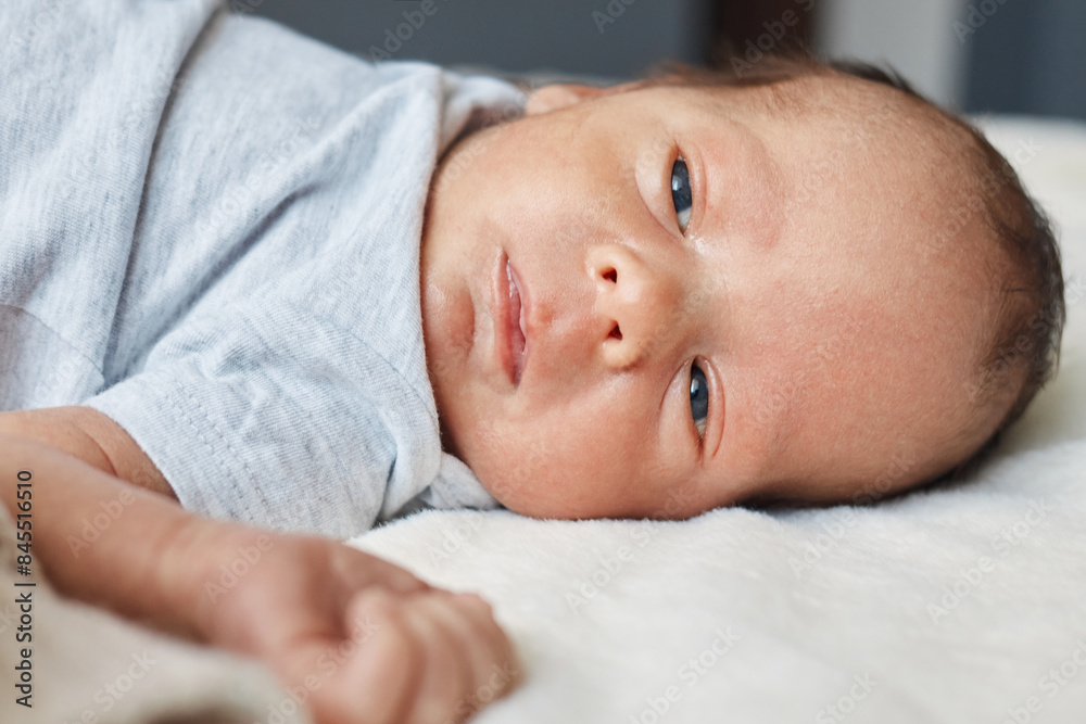 Adorable Caucasian baby wearing bodysuit lying comfortably on the bed at home child resting comfortably looking peaceful and innocent Adorable Caucasian baby wearing bodysuit lying comfortably on the bed at home child resting comfortably looking peaceful and innocent