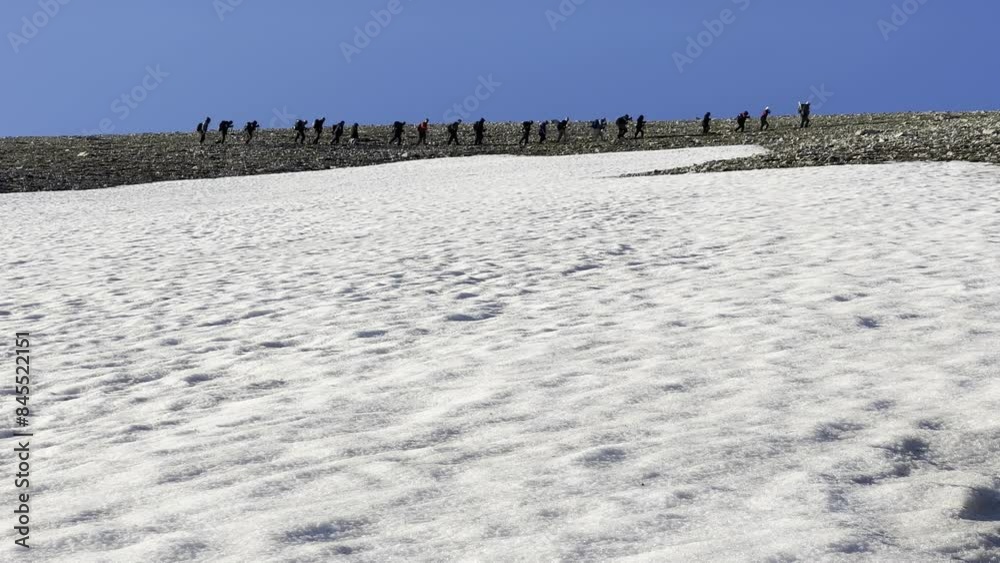Sportive climbing activity of a large group of mountaineers towards the snowy mountains at the top Sportive climbing activity of a large group of mountaineers towards the snowy mountains at the top