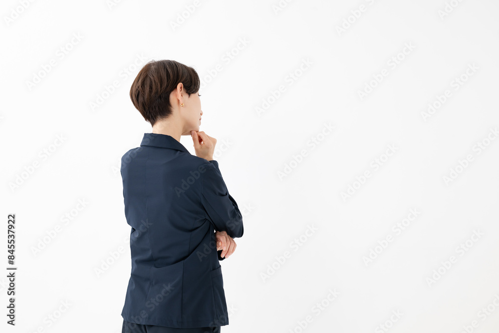 スーツ姿で悩む女性の後ろ姿 スーツ姿で悩む女性の後ろ姿