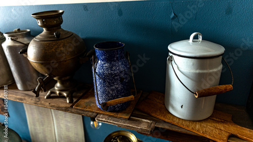 Vintage collection of kitchenware displayed on a wooden shelf against a blue wall