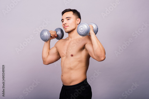Shirtless bodybuilder showing his great body and holding dumbell.
