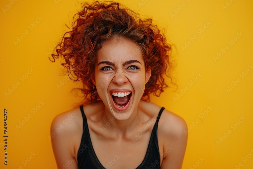 Astonished young woman in yellow shirt with wide eyes and open mouth, isolated on a bright yellow background Astonished young woman in yellow shirt with wide eyes and open mouth, isolated on a bright yellow background