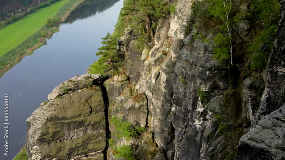 Early morning time. The goose bird sits on mountain. Sun's rays fall on impressive rock formations. A river flowing nearby. View from the Bastei Bridge. Saxon Switzerland. Germany Early morning time. The goose bird sits on mountain. Sun's rays fall on impressive rock formations. A river flowing nearby. View from the Bastei Bridge. Saxon Switzerland. Germany