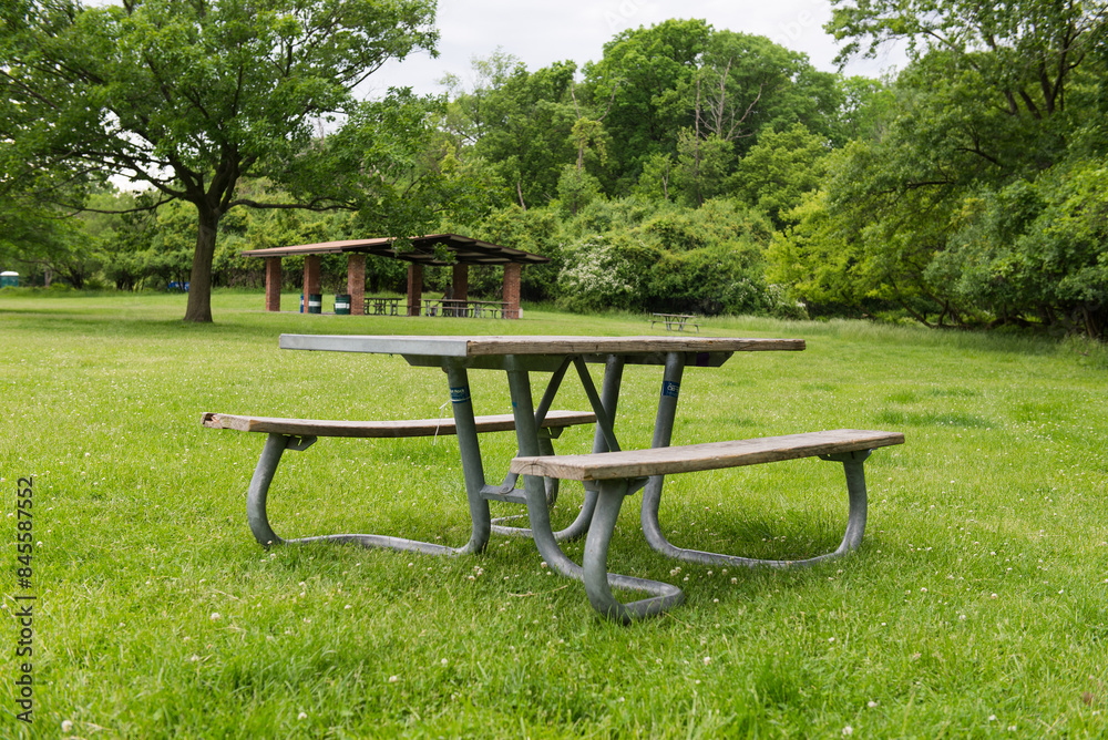 Park Picnic table bench rest relax outdoors. Benches and tables on green grass in recreational area. Park Picnic table bench rest relax outdoors. Benches and tables on green grass in recreational area.
