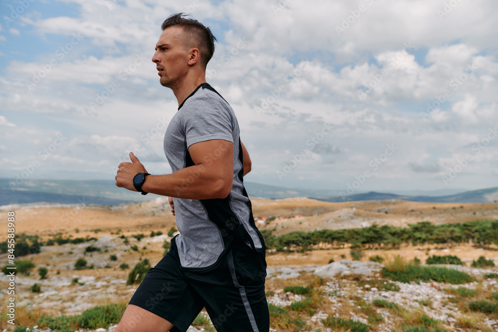 Determined Athlete Running Through Rugged Mountain Terrain at Sunrise. Determined Athlete Running Through Rugged Mountain Terrain at Sunrise.