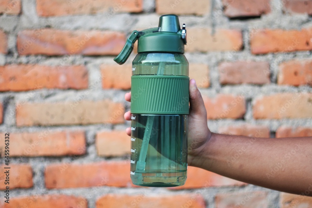 man holding bottle of drink on blurred background, closeup