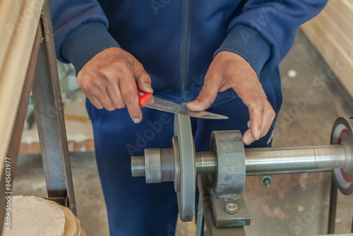 Man grinds abrasive cutting and sharpening stones for knives.Motion blur