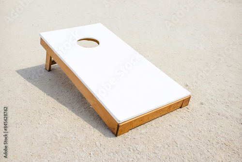 White Cornhole Board on a Sandy Surface