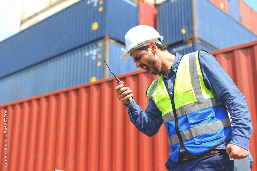 container operators wearing helmets and safety, vests control via ...