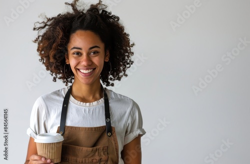 Smiling Woman Holding a Coffee Cup in a White Shirt and Black Apron