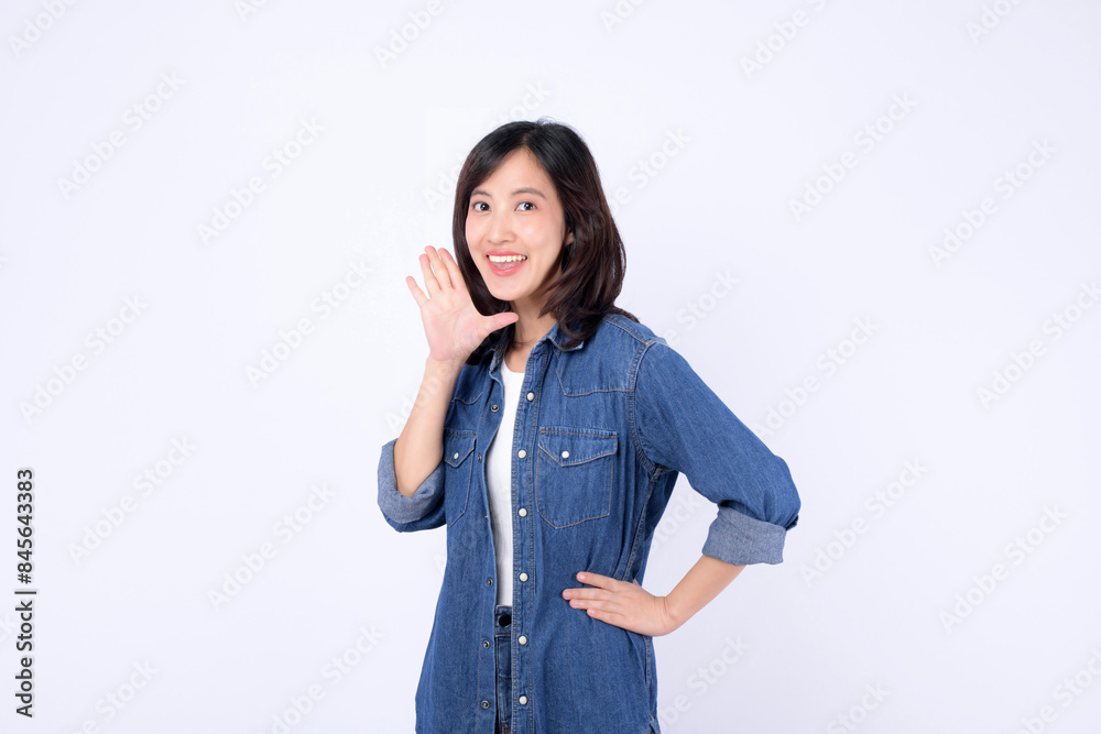 Asian woman wearing denim jean is posing with a shouting gesture against a white background. Asian woman wearing denim jean is posing with a shouting gesture against a white background.