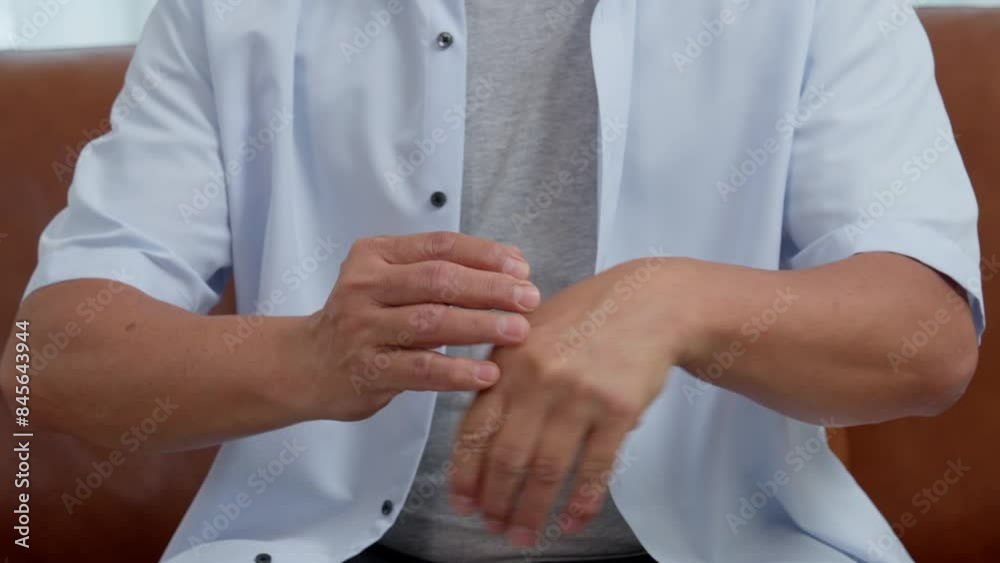 Elderly Asian male patients suffer from numbing pain in hands from rheumatoid arthritis. Senior men massage his hand with wrist pain. Concept of joint pain, rheumatoid arthritis, and hand problems. Elderly Asian male patients suffer from numbing pain in hands from rheumatoid arthritis. Senior men massage his hand with wrist pain. Concept of joint pain, rheumatoid arthritis, and hand problems.