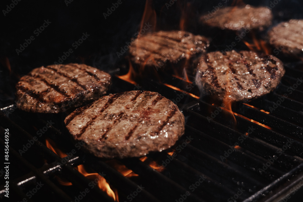 hamburgers cooking on the grill with open flame hamburgers cooking on the grill with open flame