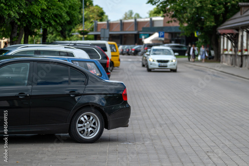 Black car parked on city street. Background with selective focus and copy space.