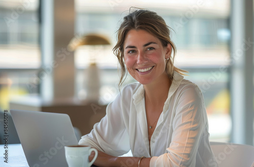 Smiling Woman Working on Laptop in Modern Cafe