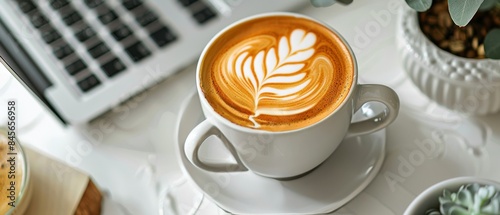 A Cup of Latte With Leaf Art on a White Tabletop