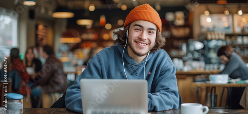 Young Man Using Laptop While Sitting in Cafe