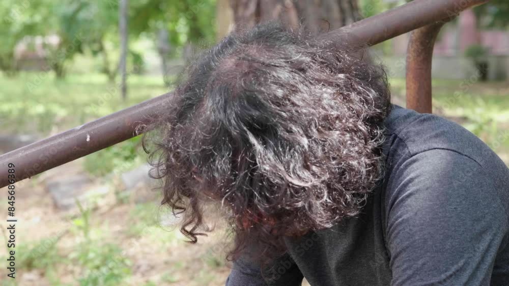 30-year-old North African man with curly hair, lonely and sad on park stairs 30-year-old North African man with curly hair, lonely and sad on park stairs