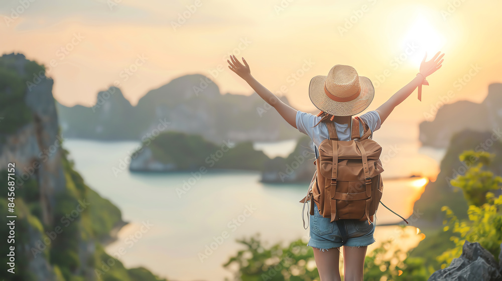 Woman with backpack and hat enjoying scenic view of mountains and sea during sunrise, embracing nature and travel adventures.