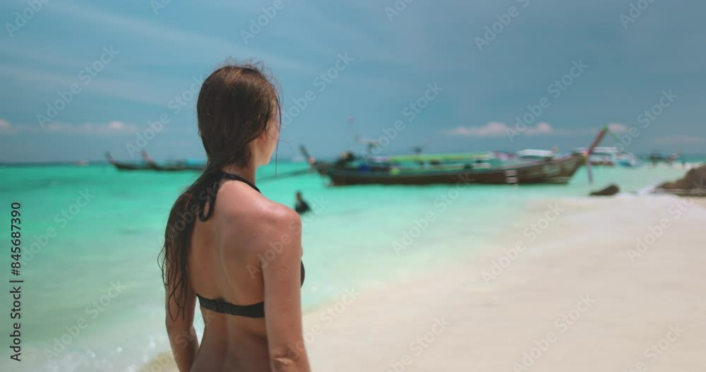 Female walking sunny white sand beach, crystal turquoise water, people swimming relax and enjoy outdoor lifestyle travel on summer holiday vacation. Wild tropical Phi Phi island, Thailand. Slow motion Female walking sunny white sand beach, crystal turquoise water, people swimming relax and enjoy outdoor lifestyle travel on summer holiday vacation. Wild tropical Phi Phi island, Thailand. Slow motion