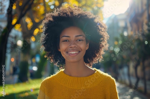 Woman With Curly Hair Smiling Outdoors in Yellow Sweater