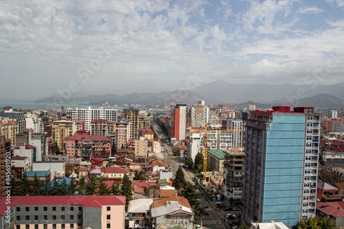 Beautiful view of a bright colorful city. Mountains are visible in the background through the fog.