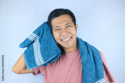 Smiling face expression young asian men wiping his hair with towel, looking at camera photo