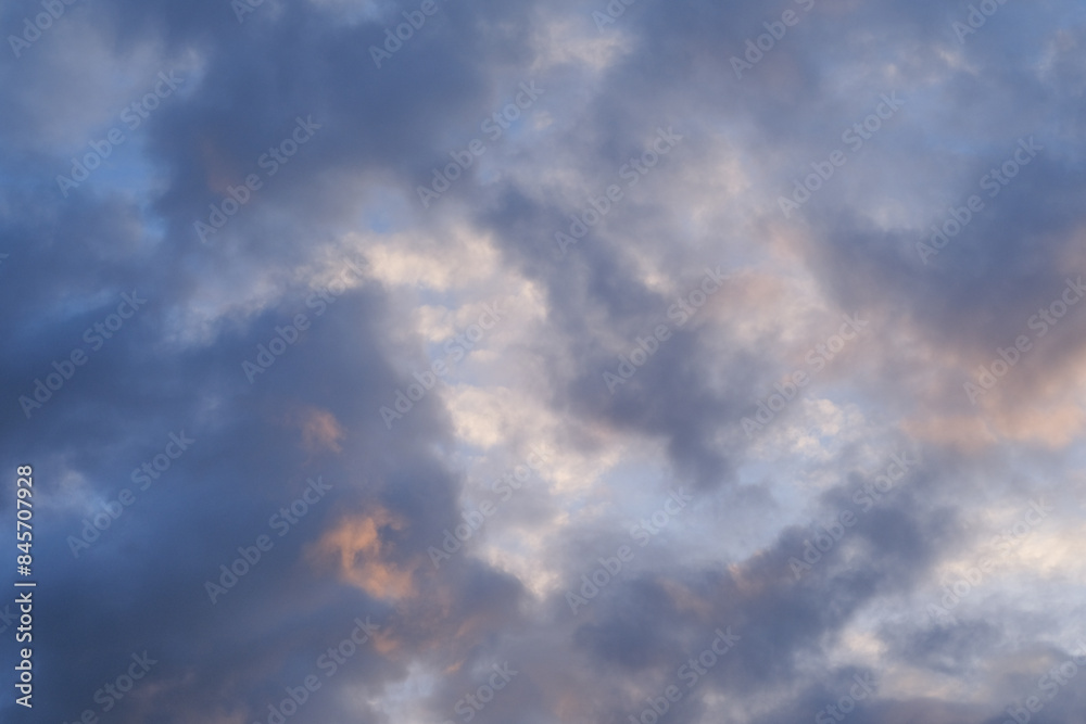 Fototapeta premium A breathtaking view of the sky during autumn evening, featuring dramatic clouds bathed in the soft colors of the setting sun