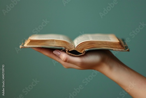 Person holds book on green background photo