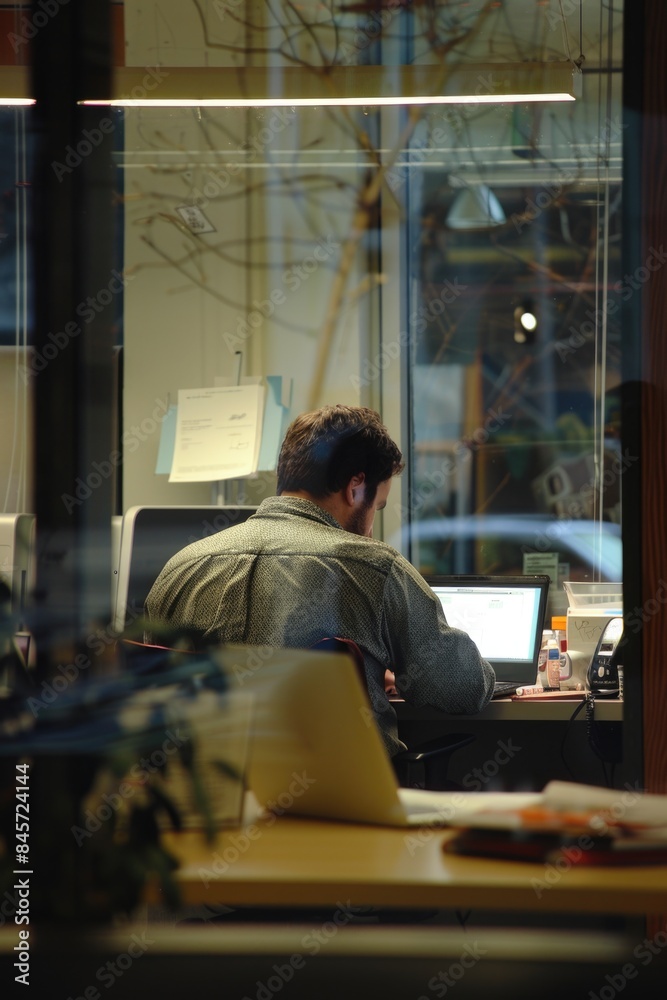 A person working on their laptop in an office setting, perfect for business or education use A person working on their laptop in an office setting, perfect for business or education use