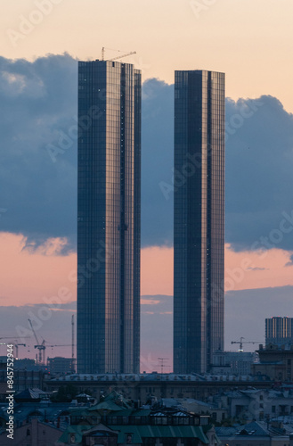 Two towers of skyscrapers of the business center against the background of clouds on a summer evening.