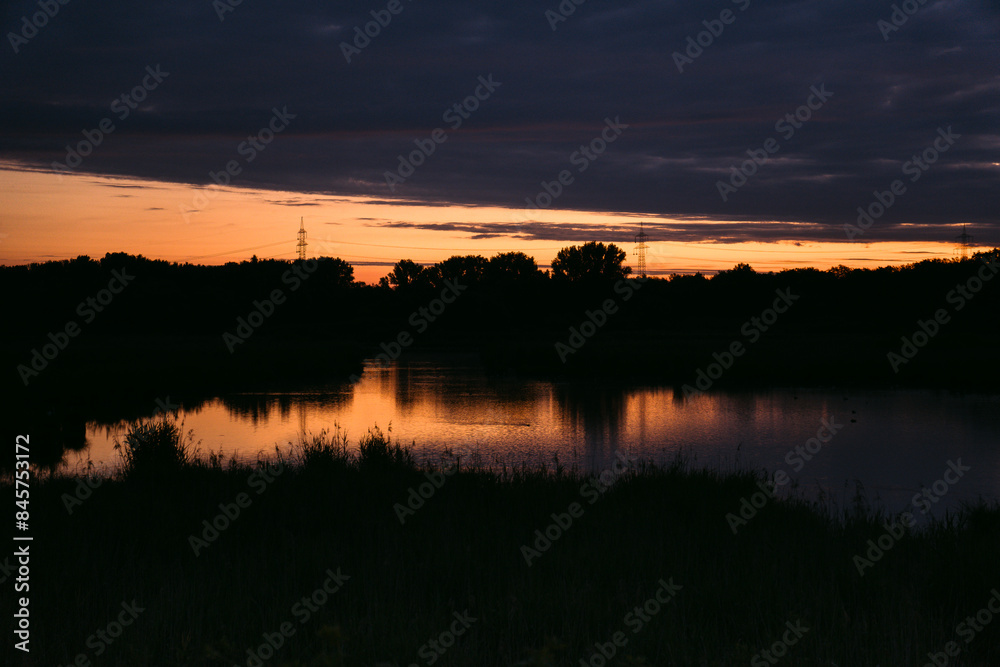 Morgenröte, Sonnenaufgang hinter Wolken an einem See in Deutschland Morgenröte, Sonnenaufgang hinter Wolken an einem See in Deutschland