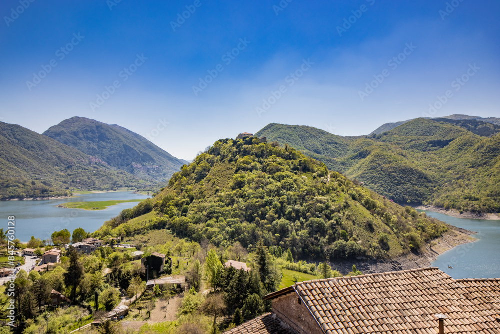 A view of Lake Turano, from the village of Castel di Tora, Rieti, Lazio, Italy. Mount Antuni, with its uninhabited village, stands in the center of the lake, surrounded by green mountains. A view of Lake Turano, from the village of Castel di Tora, Rieti, Lazio, Italy. Mount Antuni, with its uninhabited village, stands in the center of the lake, surrounded by green mountains.