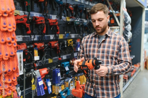 Man shopping for drill in hardware store © Serhii