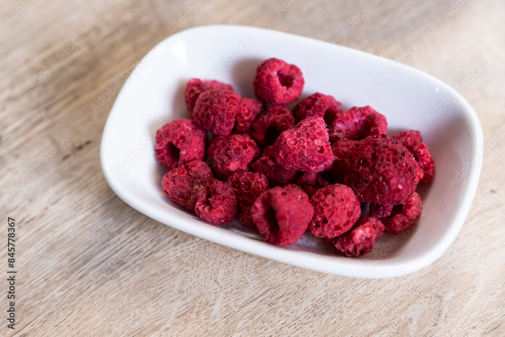 dried raspberries in bowl on wooden floor dried raspberries in bowl on wooden floor