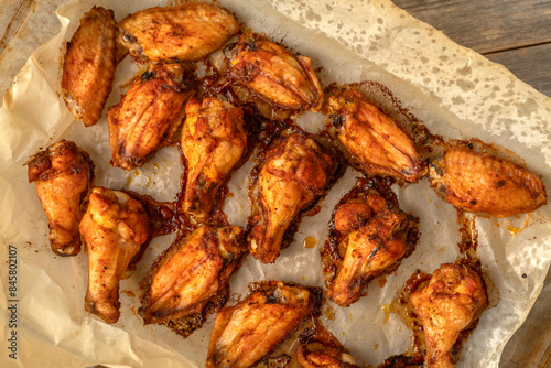Obraz na płótnie Homemade baked chicken wings in barbecue sauce in a baking dish on a gray wooden table w salonie
