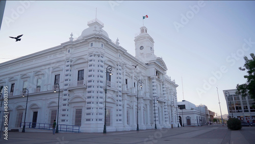 White building in the north of Mexico at morning, the wind is blowing and move a Mexican Flag photo