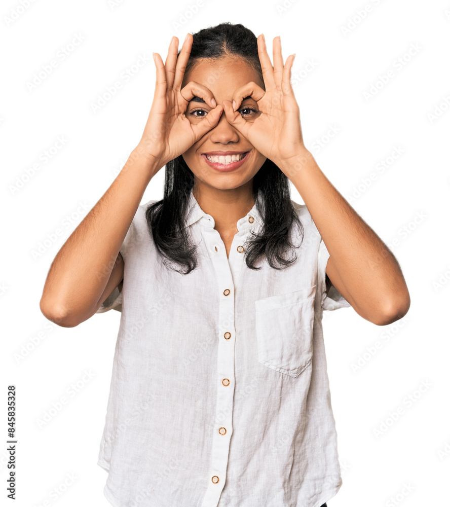 Young Filipina woman showing okay sign over eyes