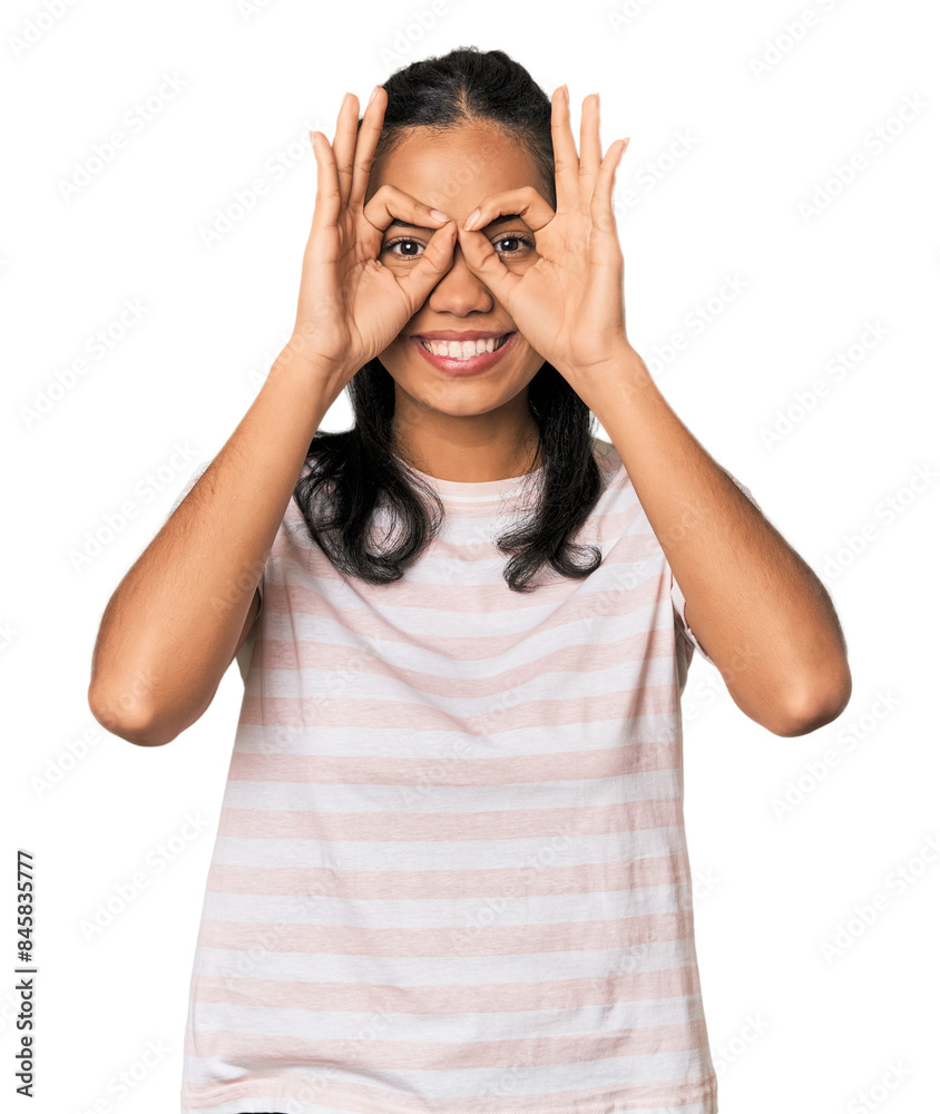 Young Filipina woman showing okay sign over eyes Young Filipina woman showing okay sign over eyes