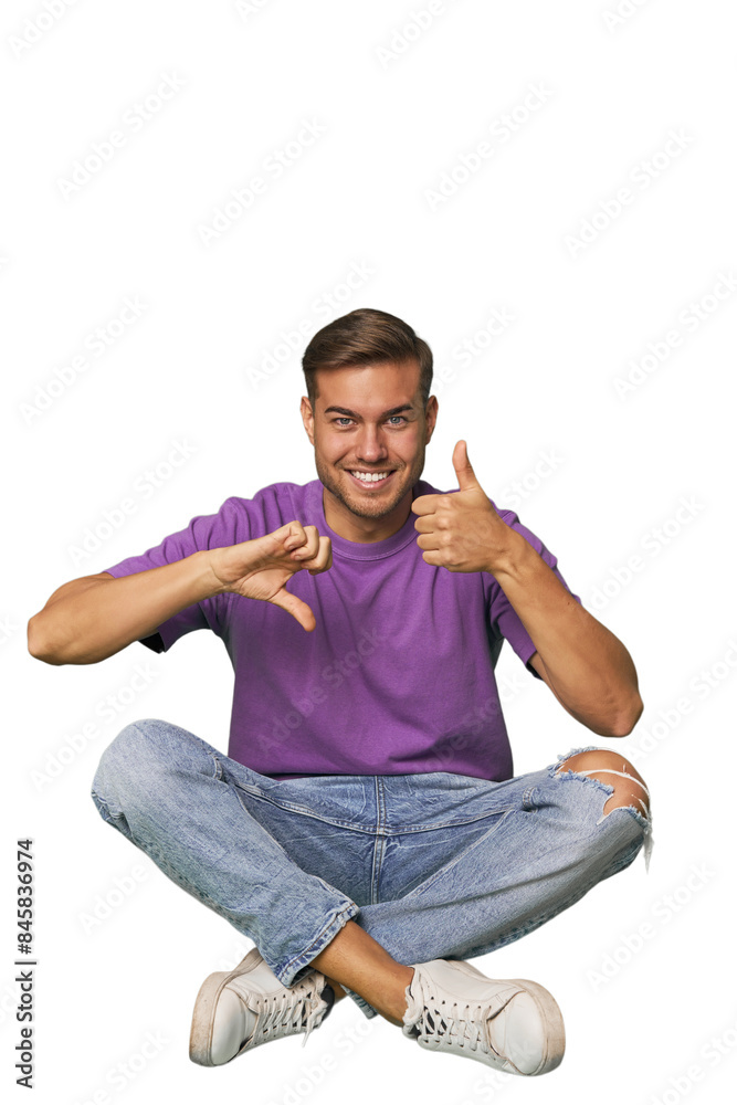 Casual man sitting on floor showing thumbs up and thumbs down, difficult choose concept Casual man sitting on floor showing thumbs up and thumbs down, difficult choose concept