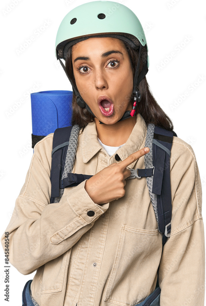 Hispanic young woman with mountain gear pointing to the side Hispanic young woman with mountain gear pointing to the side
