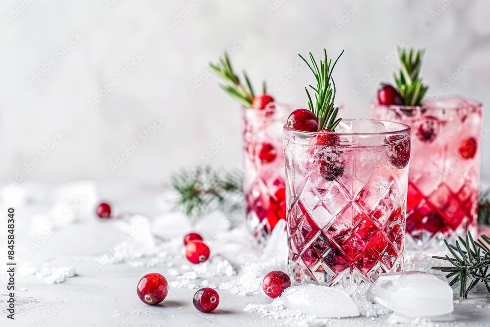 Festive cranberry cocktail with ice and rosemary on white background Festive cranberry cocktail with ice and rosemary on white background
